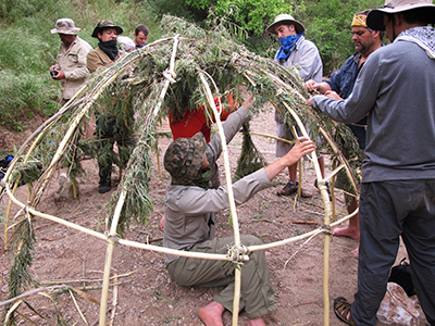 Constructing a willow parabola framework for a shelter.